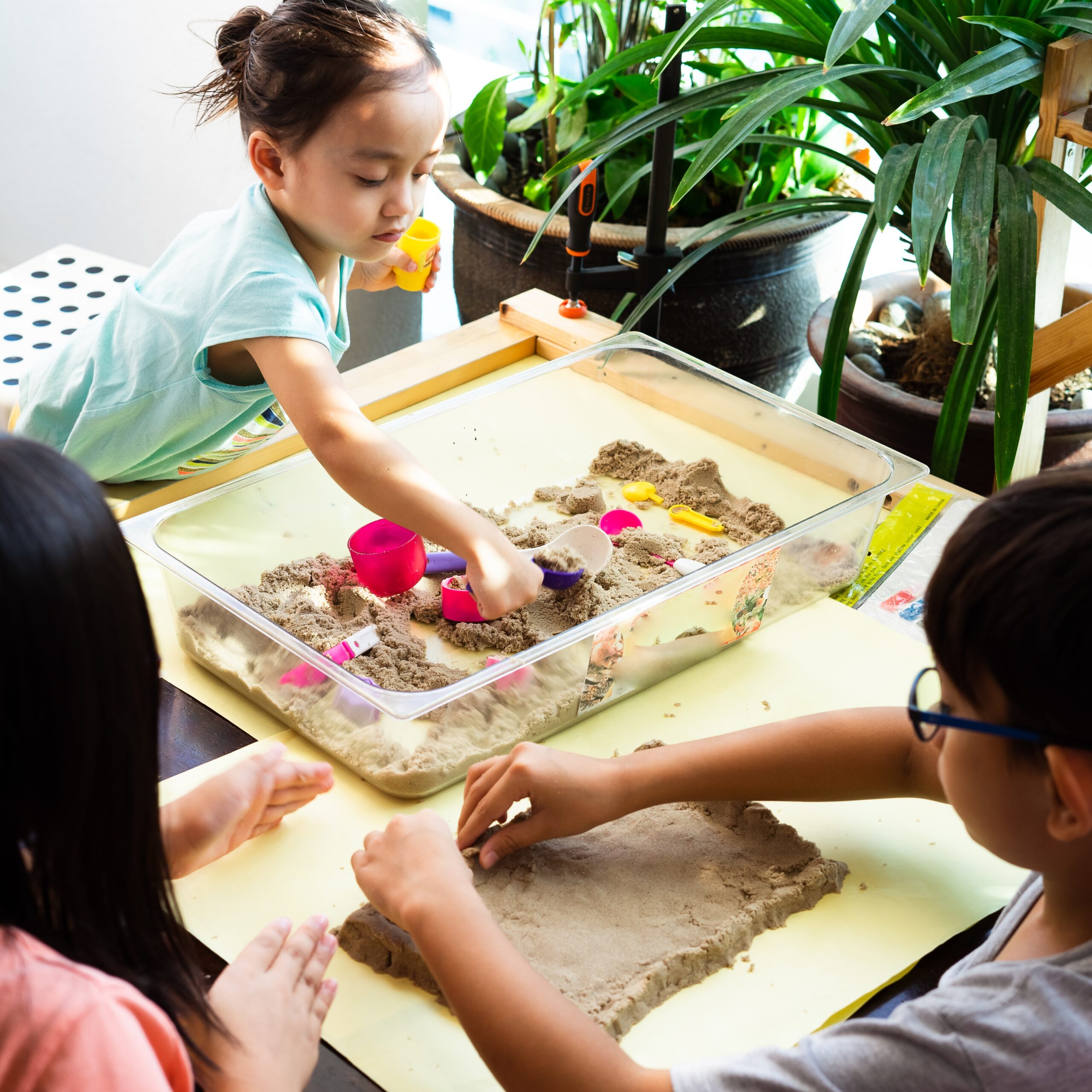 Children playing kinetic sands at home during sunrise due to the lockdown of the Coronavirus or Covid 19 outbreak. Selective focus.